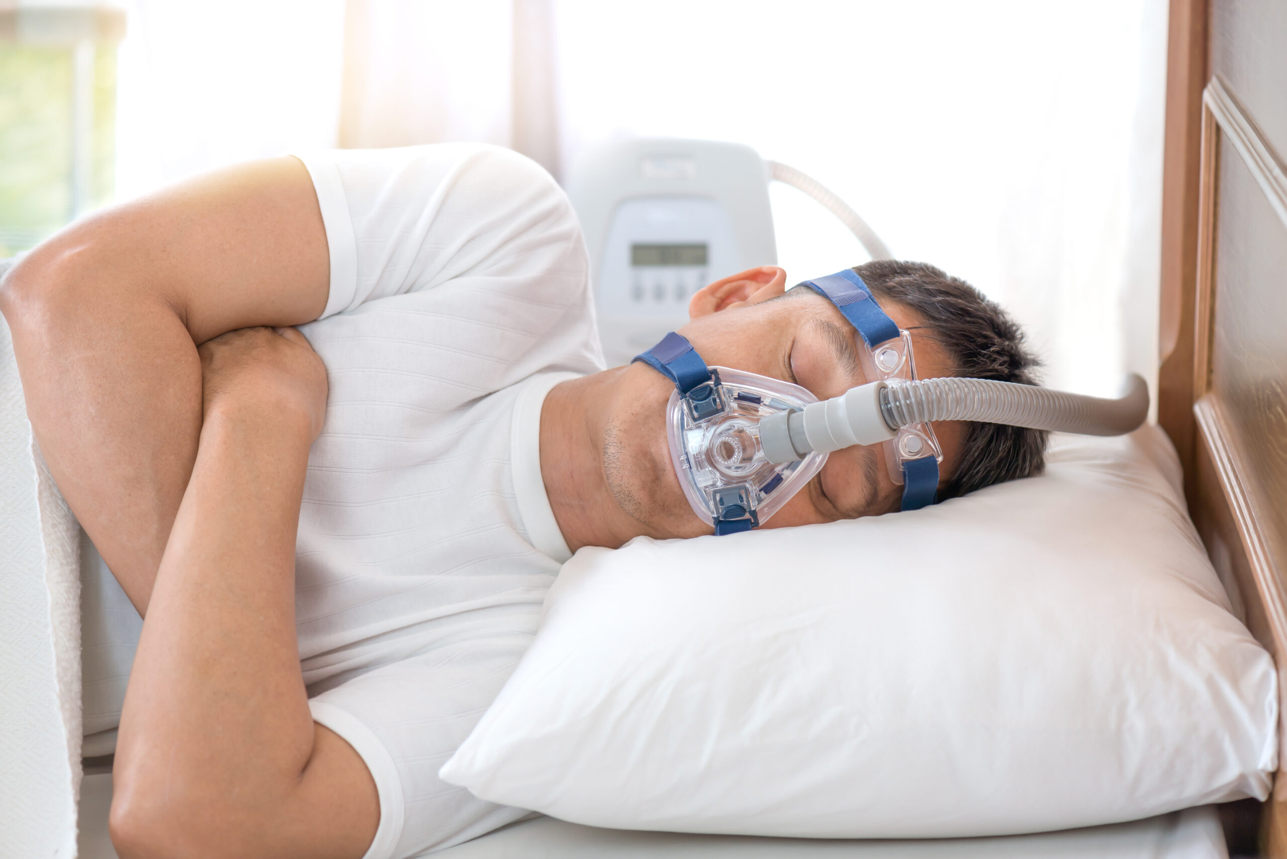 Man sleeping in bed wearing CPAP mask ,sleep apnea therapy
Happy and healthy senior man sleeping deeply on his left side without snoring